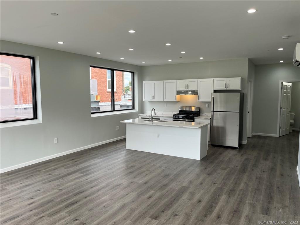 893 Main Street, Unit 202 Manchester, CT 06040 - Photo 5 of 10 a kitchen with stainless steel appliances granite countertop a stove a sink and a refrigerator