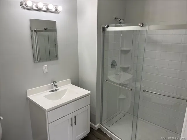 a bathroom with a shower sink and mirror