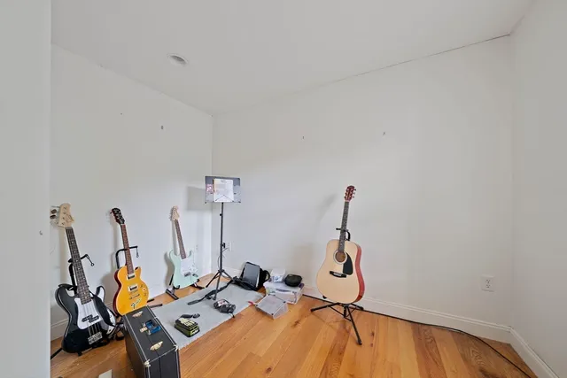 a room with gym equipment and wooden floor