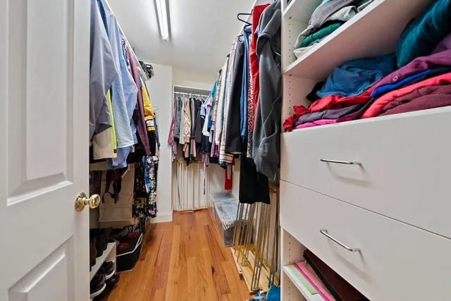 a view of walk in closet with clothes and shoes