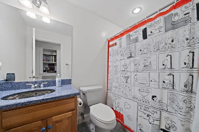 a bathroom with a granite countertop toilet sink and mirror