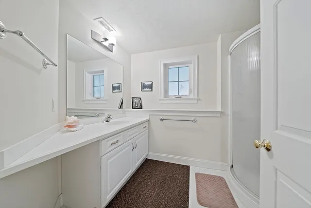 a bathroom with a double vanity sink a mirror and a bathtub