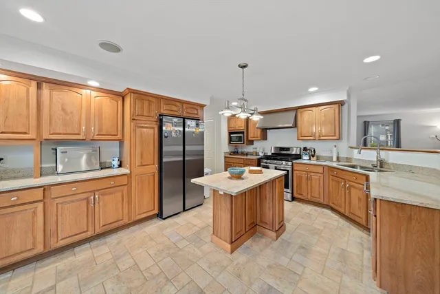 a kitchen with stainless steel appliances granite countertop a stove top oven a sink dishwasher and a refrigerator
