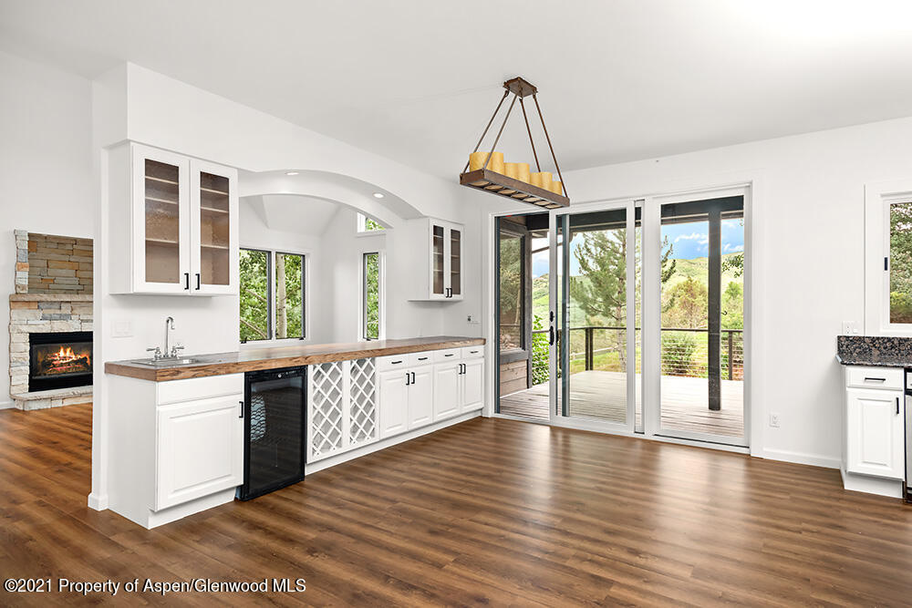 400 Medicine Bow Road Aspen, CO 81611 - Photo 11 of 58 a open kitchen with stainless steel appliances granite countertop a stove a sink dishwasher a refrigerator white cabinets and wooden floor next to a window