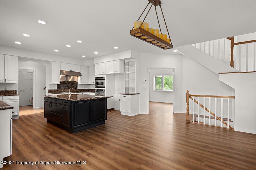 400 Medicine Bow Road Aspen, CO 81611 - Photo 12 of 58 a kitchen with stainless steel appliances kitchen island wooden floors granite top and stainless steel appliances