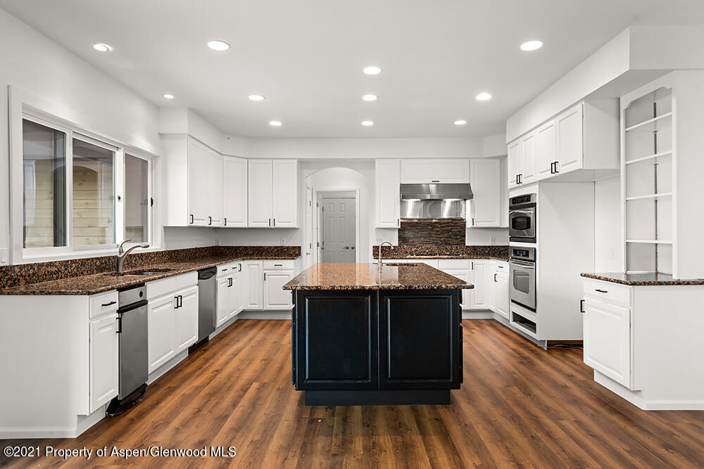 400 Medicine Bow Road Aspen, CO 81611 - Photo 15 of 58 a large kitchen with stainless steel appliances granite countertop a stove a sink dishwasher and a refrigerator with wooden floor