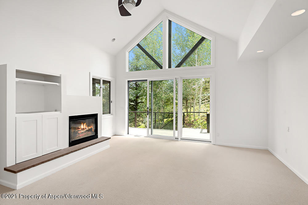 400 Medicine Bow Road Aspen, CO 81611 - Photo 16 of 58 a view of an empty room with a fireplace and a window