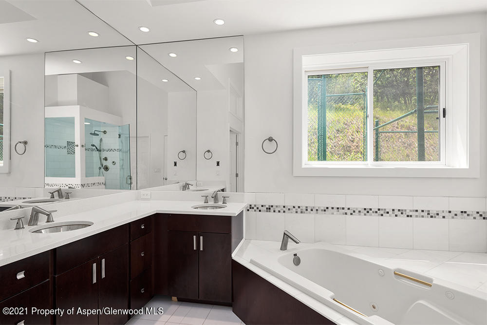 400 Medicine Bow Road Aspen, CO 81611 - Photo 18 of 58 a bathroom with a tub a sink double vanity and a mirror