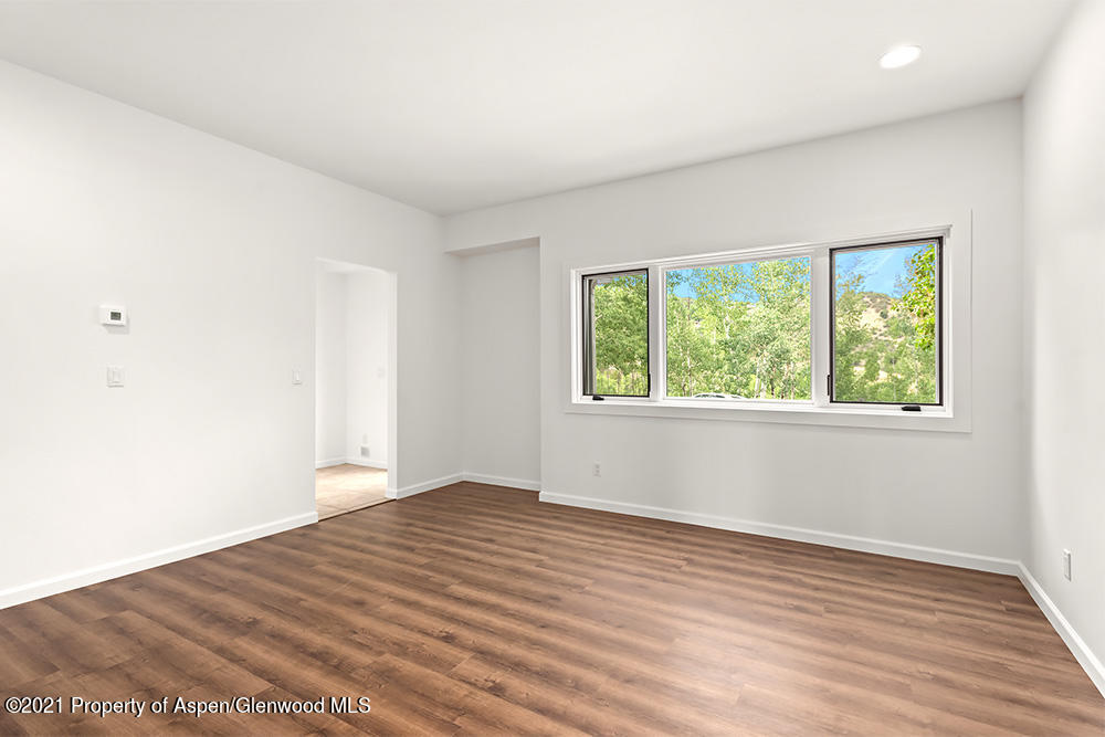 400 Medicine Bow Road Aspen, CO 81611 - Photo 21 of 58 an empty room with wooden floor and windows