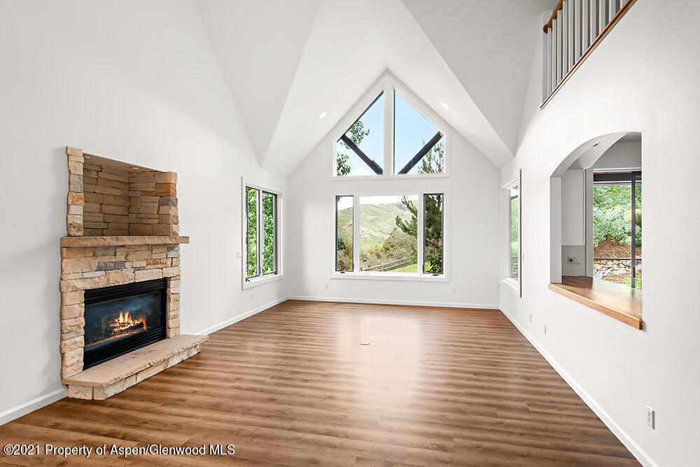 400 Medicine Bow Road Aspen, CO 81611 - Photo 7 of 58 a view of a livingroom with wooden floor a fireplace and windows