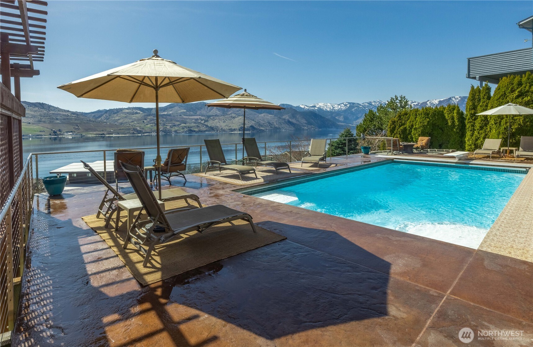 217 Riviera Drive Chelan, WA 98816 - Photo 1 of 38 a view of a swimming pool with a table and chairs under an umbrella