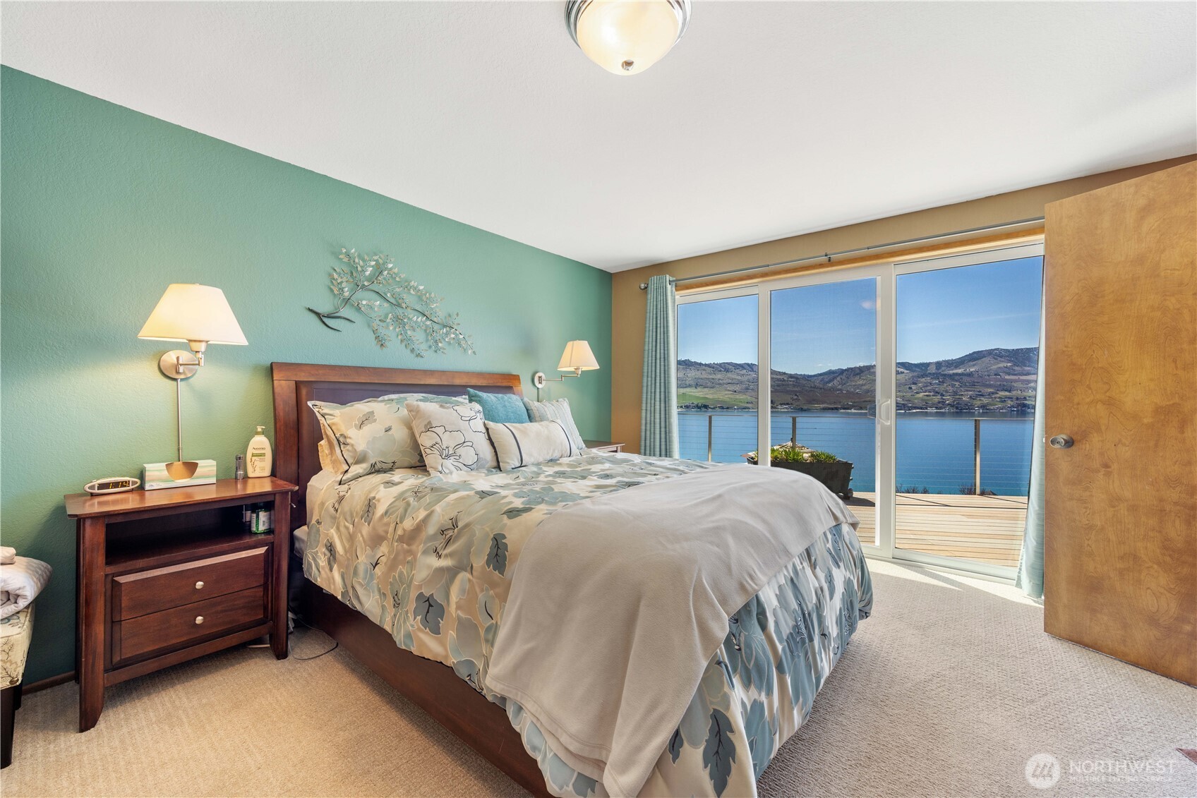 217 Riviera Drive Chelan, WA 98816 - Photo 11 of 38 a bedroom with a bed and a lamp next to a window