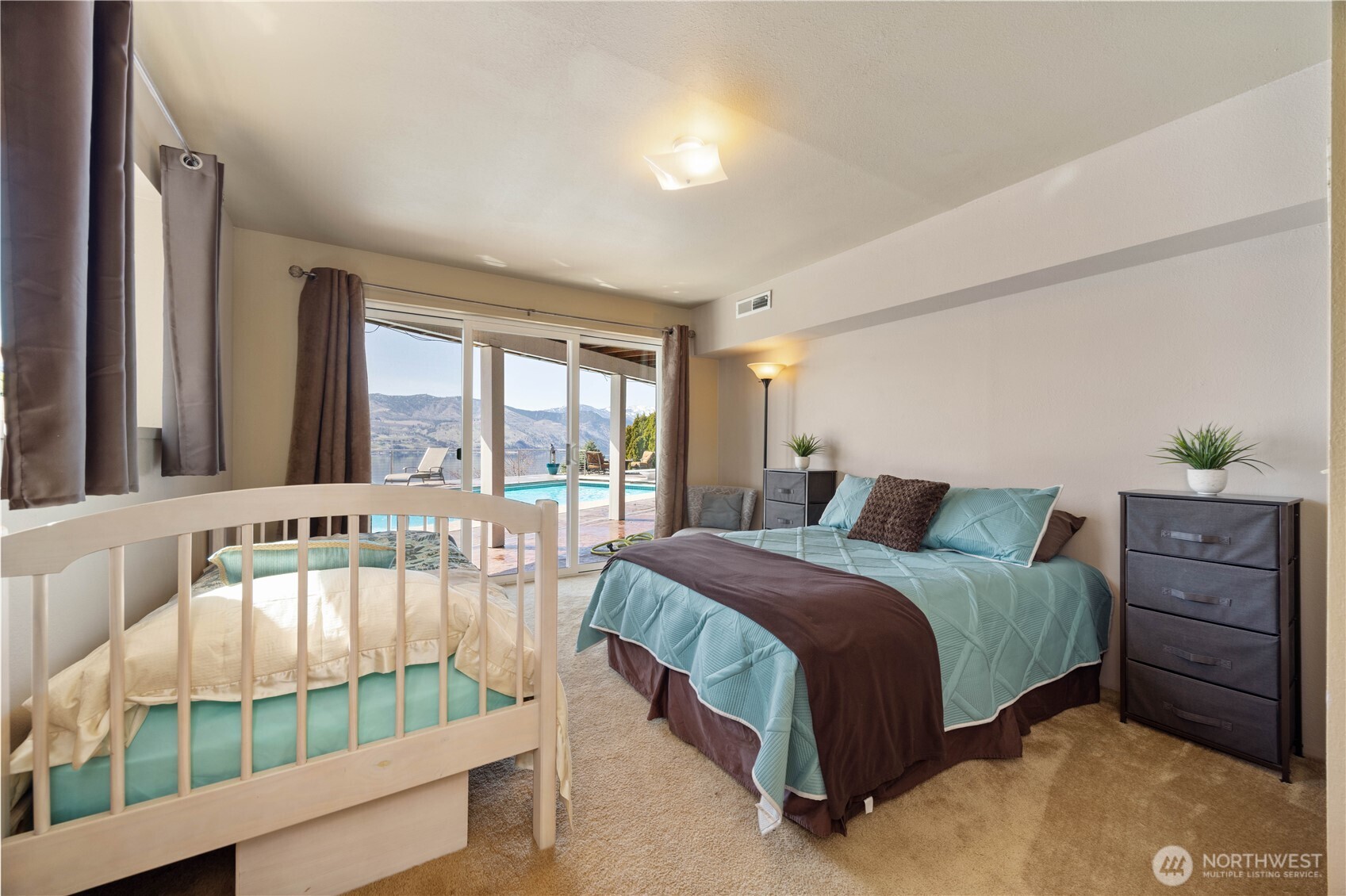 217 Riviera Drive Chelan, WA 98816 - Photo 22 of 38 a spacious bedroom with a bed and a window