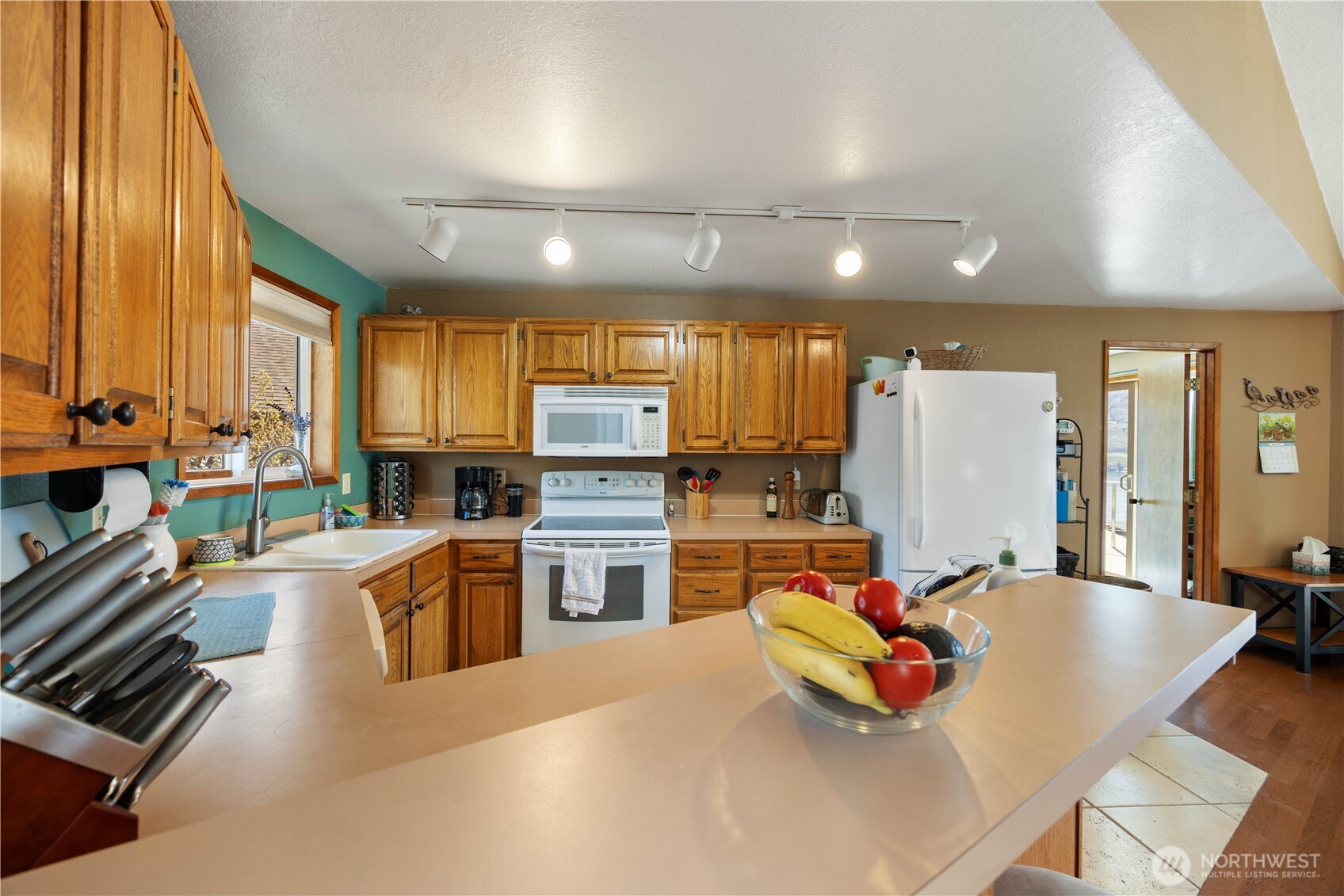 217 Riviera Drive Chelan, WA 98816 - Photo 10 of 38 a kitchen with stainless steel appliances kitchen island granite countertop a refrigerator and a stove top oven
