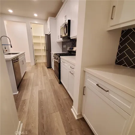 a kitchen with a sink a refrigerator and cabinets