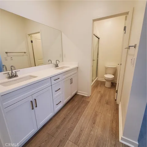 a spacious bathroom with a double vanity sink toilet and shower