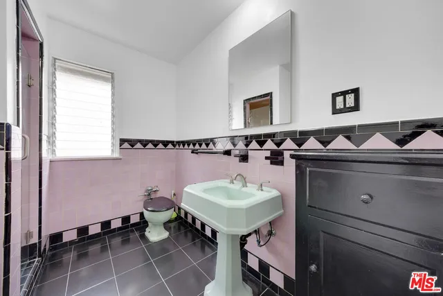 a bathroom with a sink a toilet and a mirror