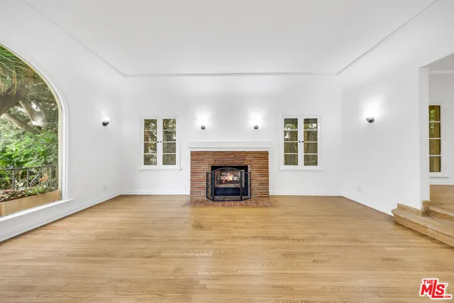 a view of an empty room with window and fire place