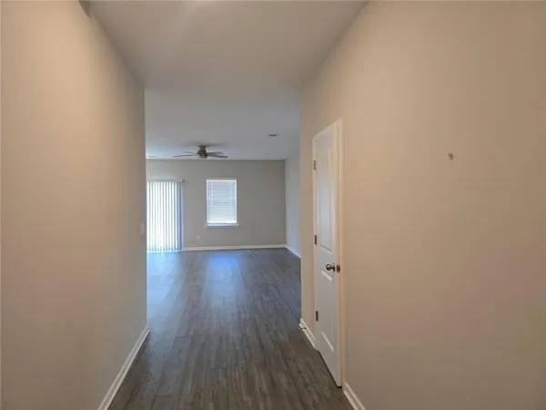 a view of a hallway with wooden floor and a window