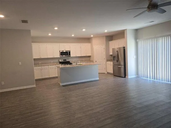 a kitchen with stainless steel appliances granite countertop a refrigerator and a stove top oven