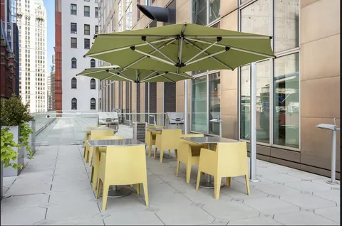 a view of a patio with a table and chairs under an umbrella