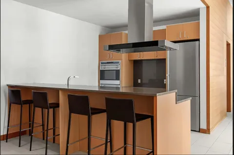 a kitchen with a sink and chairs