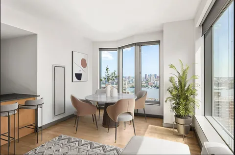 a dining room with furniture and a floor to ceiling window