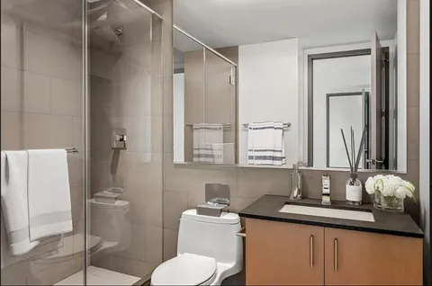 a bathroom with a sink vanity mirror and toilet