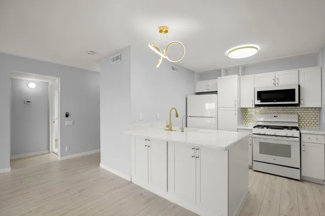 a kitchen with cabinets a sink and stainless steel appliances