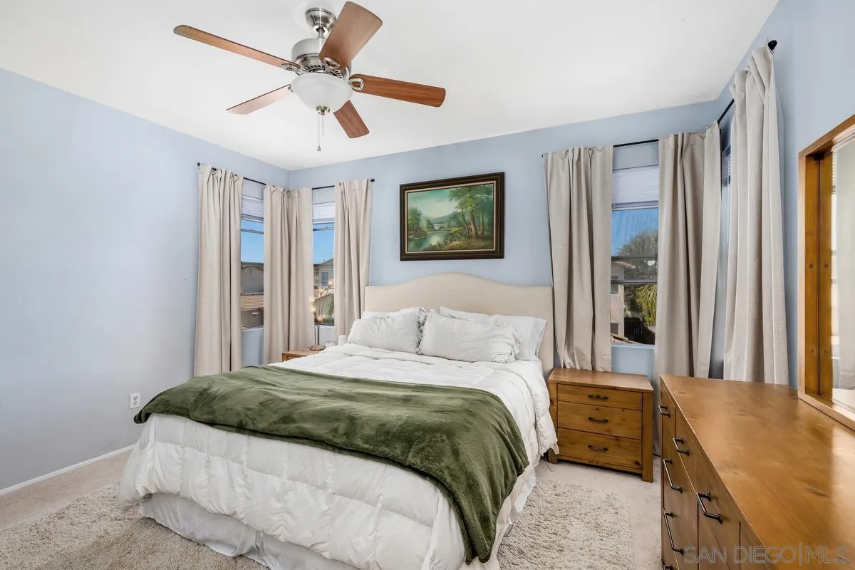 39537 Tischa Drive Temecula, CA 92591 - Photo 19 of 35 a bedroom with a large bed and a chandelier fan