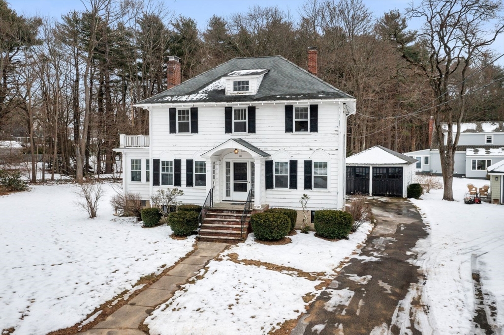 a front view of a house with a yard covered in snow