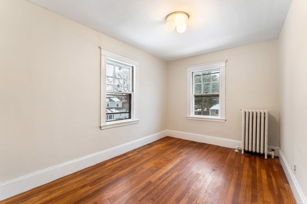 10 Hinckley Road Newton, MA 02468 - Photo 29 of 41 an empty room with wooden floor and windows