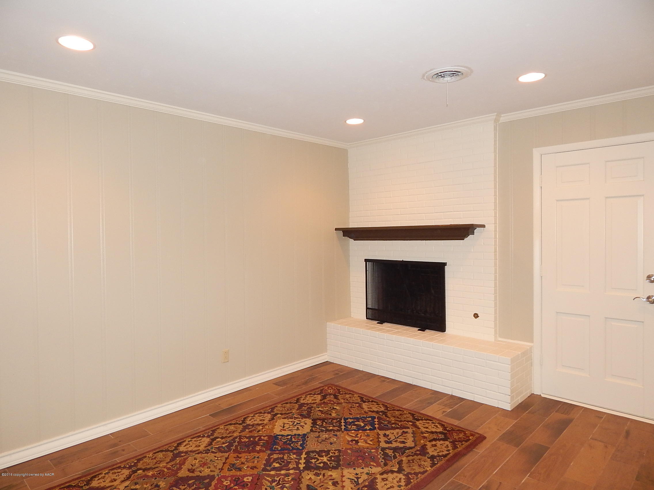 6703 Elmhurst Road Amarillo, TX 79106 - Photo 8 of 36 a view of an empty room with wooden floor and a fireplace