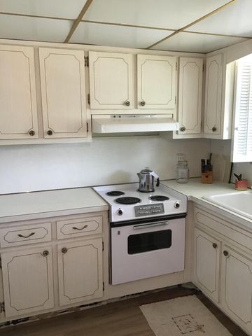 a kitchen with white cabinets and white appliances