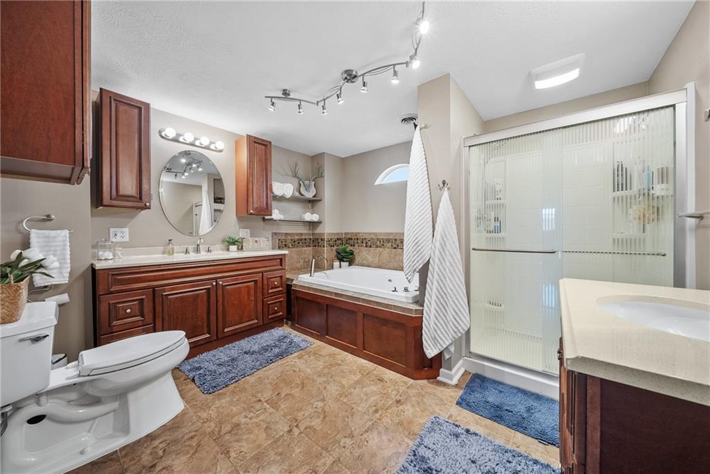 3032 Investors Road Washington, PA 15301 - Photo 24 of 50 Owner’s suite positioned in its own private section of the home, offering a spacious bedroom, walk-in closet with custom organization, and a spa-style bathroom with soaking tub, dual vanities, stand-up shower, and stackable washer and dryer.