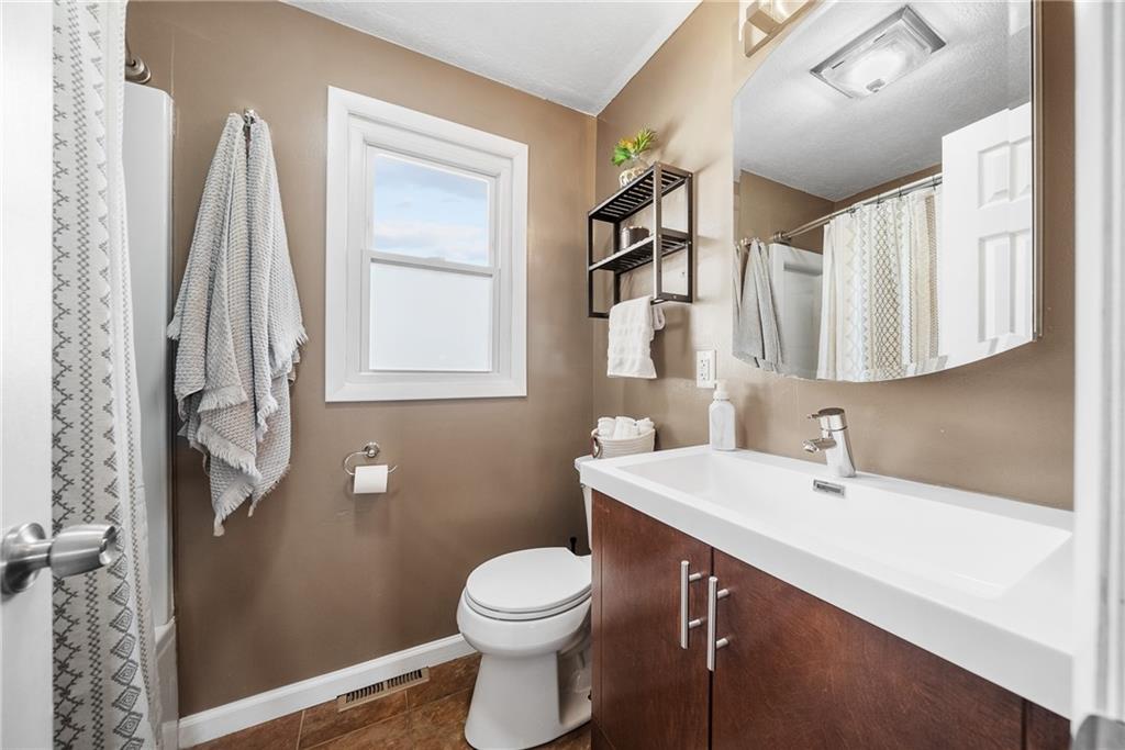 3032 Investors Road Washington, PA 15301 - Photo 29 of 50 Modern hall bathroom with tub and shower combo, single vanity, toilet, and ceramic tile flooring, designed to serve the two secondary bedrooms.