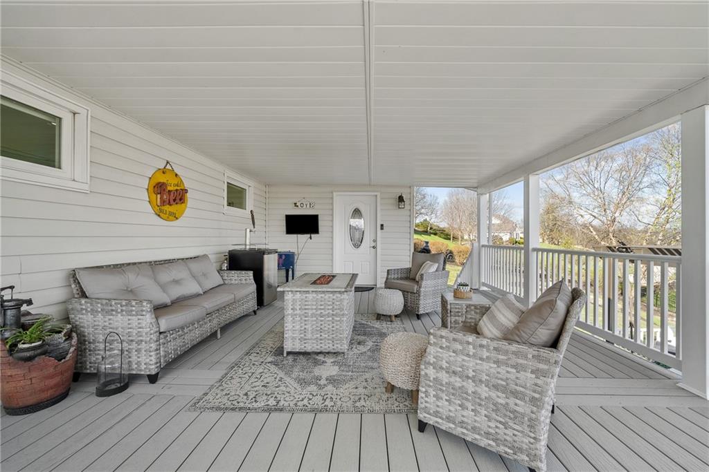 3032 Investors Road Washington, PA 15301 - Photo 40 of 50 Expansive 27x15 covered composite deck, flows directly from the kitchen and dining area with steps to the lower yard, creating an ideal setting for entertaining, outdoor dining, firepit evenings, and sunset views.