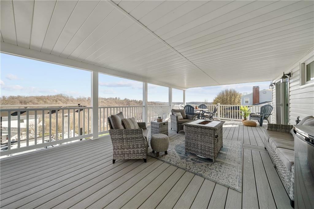 3032 Investors Road Washington, PA 15301 - Photo 41 of 50 Expansive 27x15 covered composite deck, flows directly from the kitchen and dining area with steps to the lower yard, creating an ideal setting for entertaining, outdoor dining, firepit evenings, and sunset views.