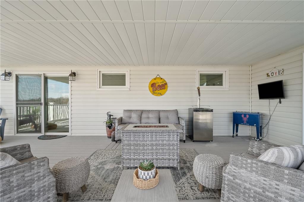 3032 Investors Road Washington, PA 15301 - Photo 42 of 50 Expansive 27x15 covered composite deck, flows directly from the kitchen and dining area with steps to the lower yard, creating an ideal setting for entertaining, outdoor dining, firepit evenings, and sunset views.