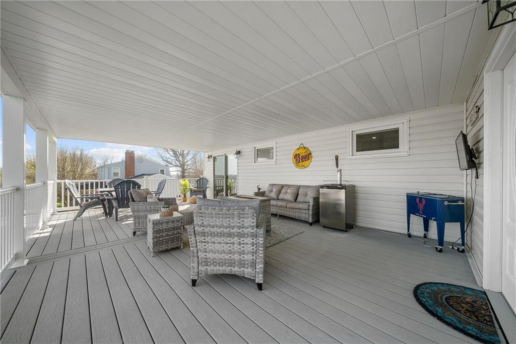 3032 Investors Road Washington, PA 15301 - Photo 43 of 50 Expansive 27x15 covered composite deck, flows directly from the kitchen and dining area with steps to the lower yard, creating an ideal setting for entertaining, outdoor dining, firepit evenings, and sunset views.