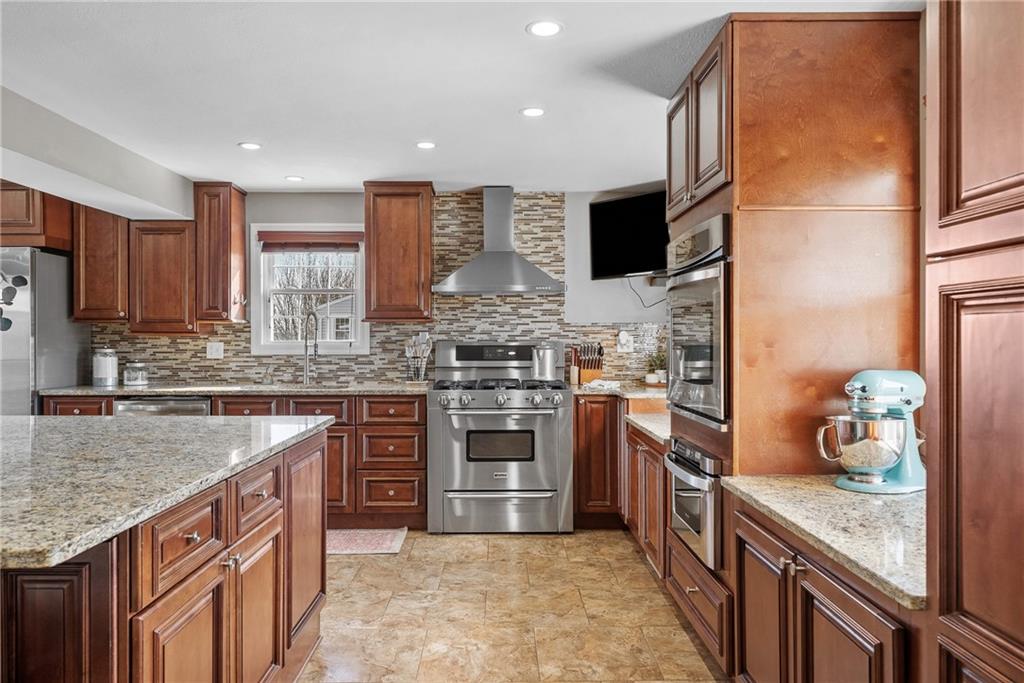 3032 Investors Road Washington, PA 15301 - Photo 7 of 50 A true centerpiece of the home, this 26x22 open kitchen and dining area is built for gathering. A 6.5x6.5 island anchors the space with seating for six or more, surrounded by custom cabinetry, granite countertops, a built-in wall oven and microwave, professional-grade refrigerator, and a Kenmore Elite 5-burner gas stove with vent hood.