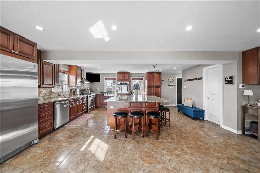 3032 Investors Road Washington, PA 15301 - Photo 8 of 50 A true centerpiece of the home, this 26x22 open kitchen and dining area is built for gathering. A 6.5x6.5 island anchors the space with seating for six or more, surrounded by custom cabinetry, granite countertops, a built-in wall oven and microwave, professional-grade refrigerator, and a Kenmore Elite 5-burner gas stove with vent hood.