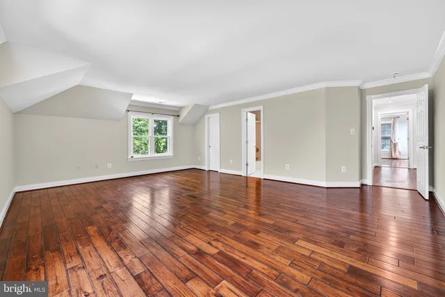 a spacious en suite bathroom with a granite countertop double vanity sink a mirror a vanity and a bathtub