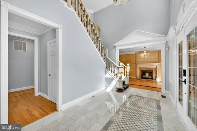 a view of an empty room with wooden floor fireplace and a window