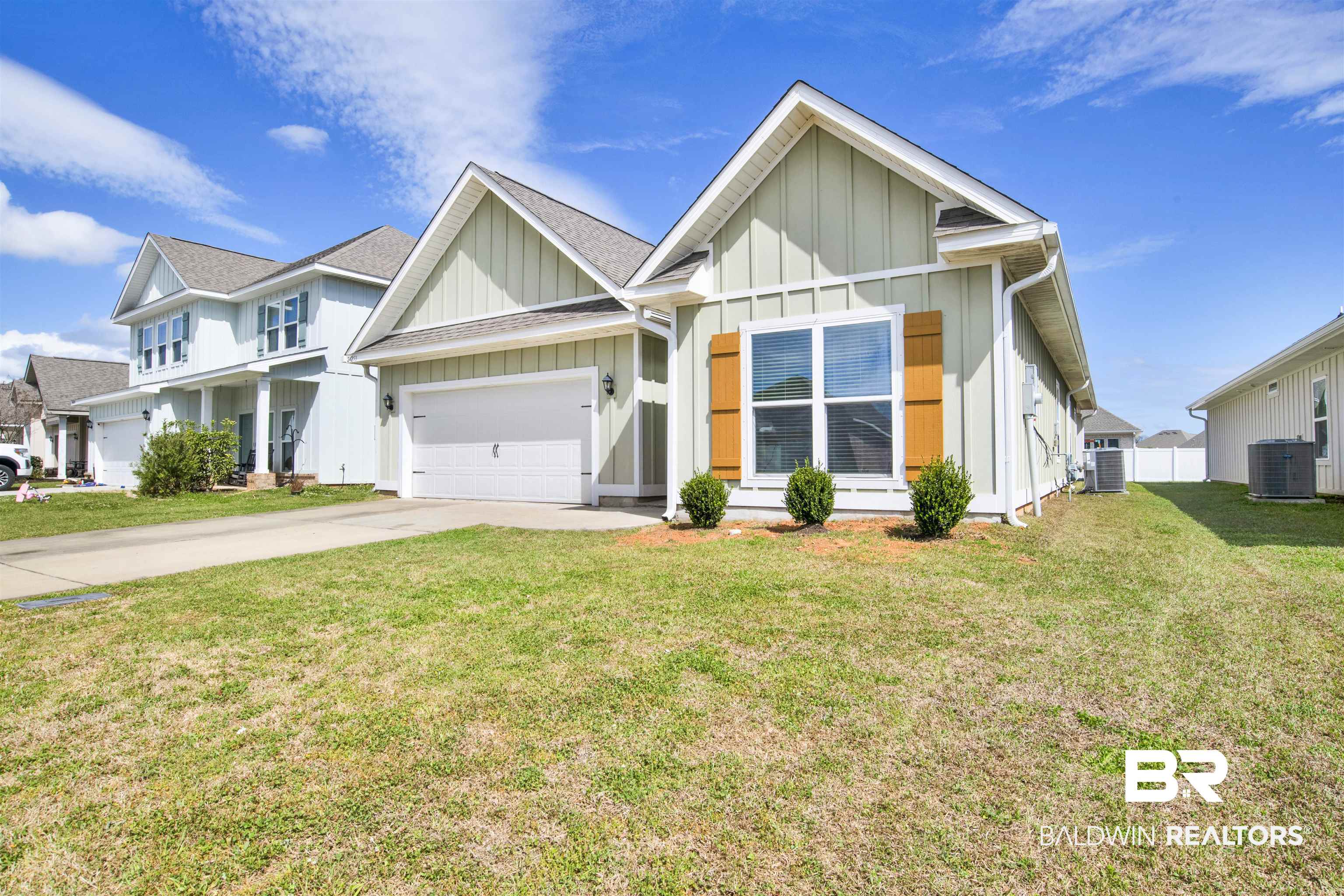24253 Alydar Loop Daphne, AL 36526 - Photo 2 of 44 View of front of home featuring board and batten siding, driveway, a front lawn, and a garage