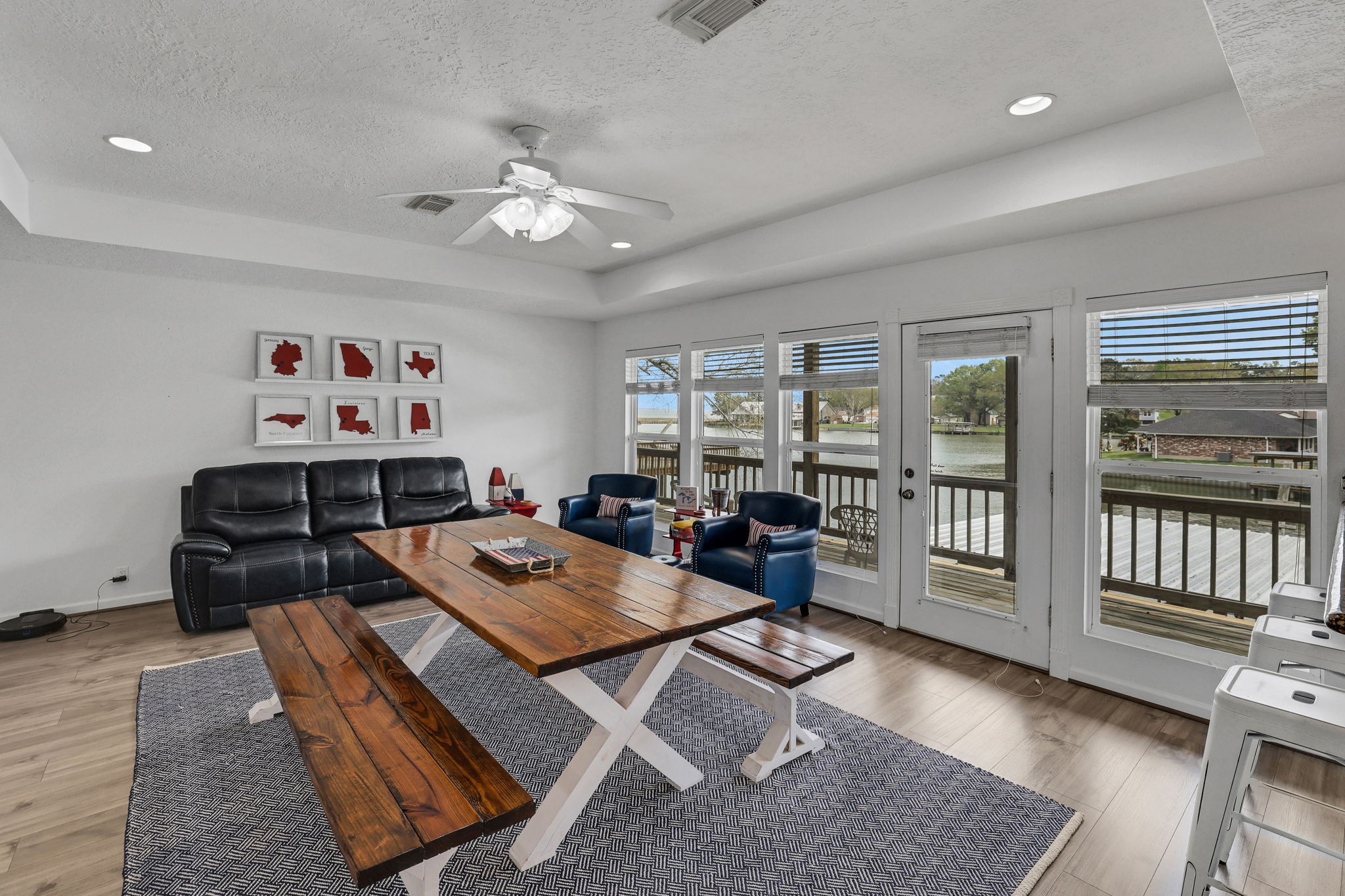 331 Holiday Lane Coldspring, TX 77331 - Photo 16 of 36 This inviting second story dining area features large windows and a glass door offering beautiful water views. and modern decor. The room is bright and airy, thanks to recessed lighting and a ceiling fan, with access to a deck for outdoor enjoyment.