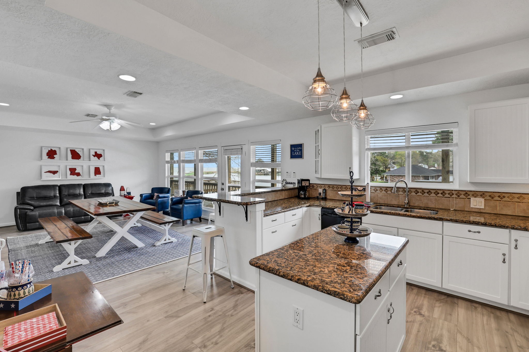 331 Holiday Lane Coldspring, TX 77331 - Photo 19 of 36 This open-concept space features a modern kitchen leading into a bright living area with large windows offering a warm and inviting atmosphere.
