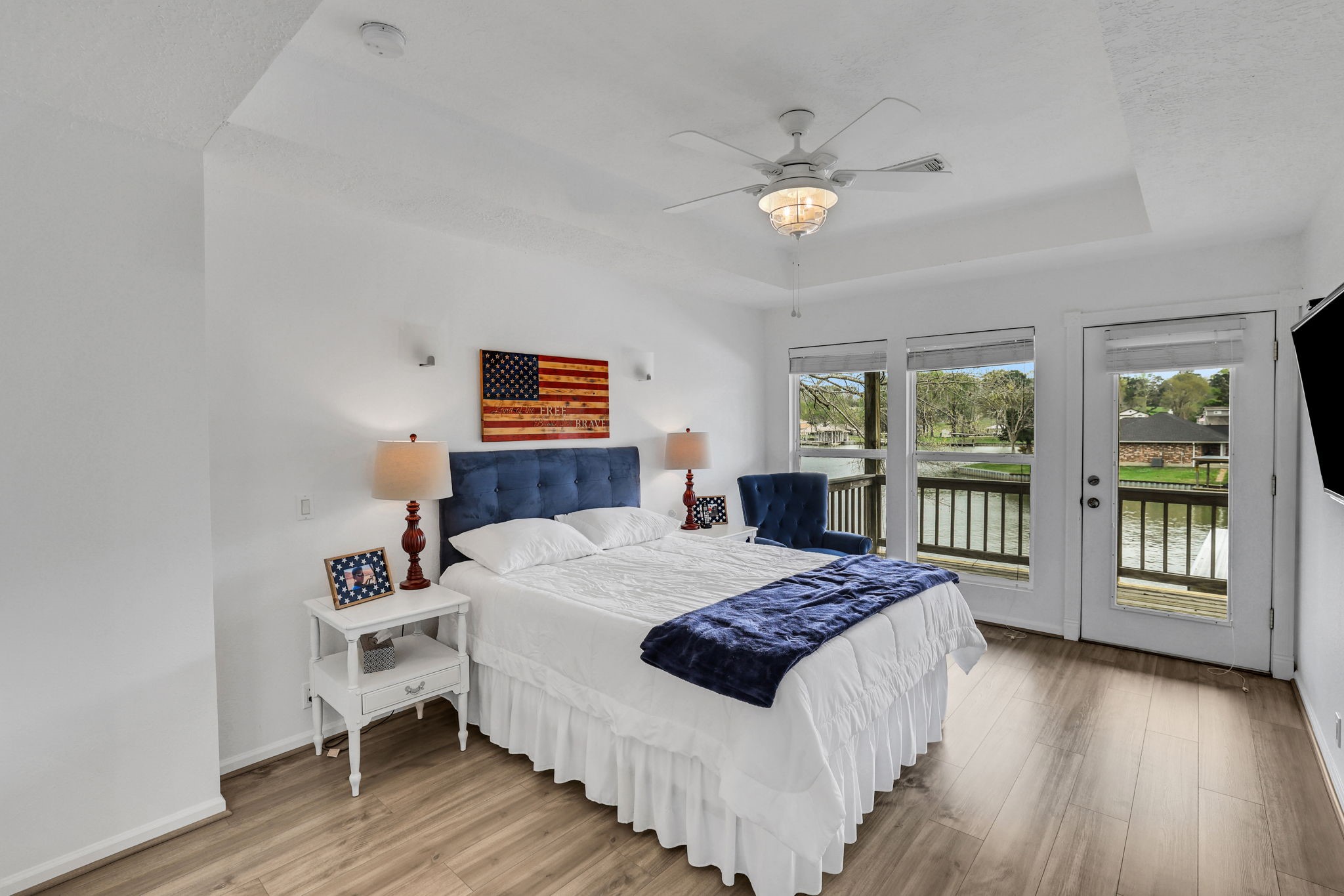 331 Holiday Lane Coldspring, TX 77331 - Photo 33 of 36 This bright primary bedroom features and a ceiling fan, large windows and a glass door offering access to a balcony with serene waterfront views.