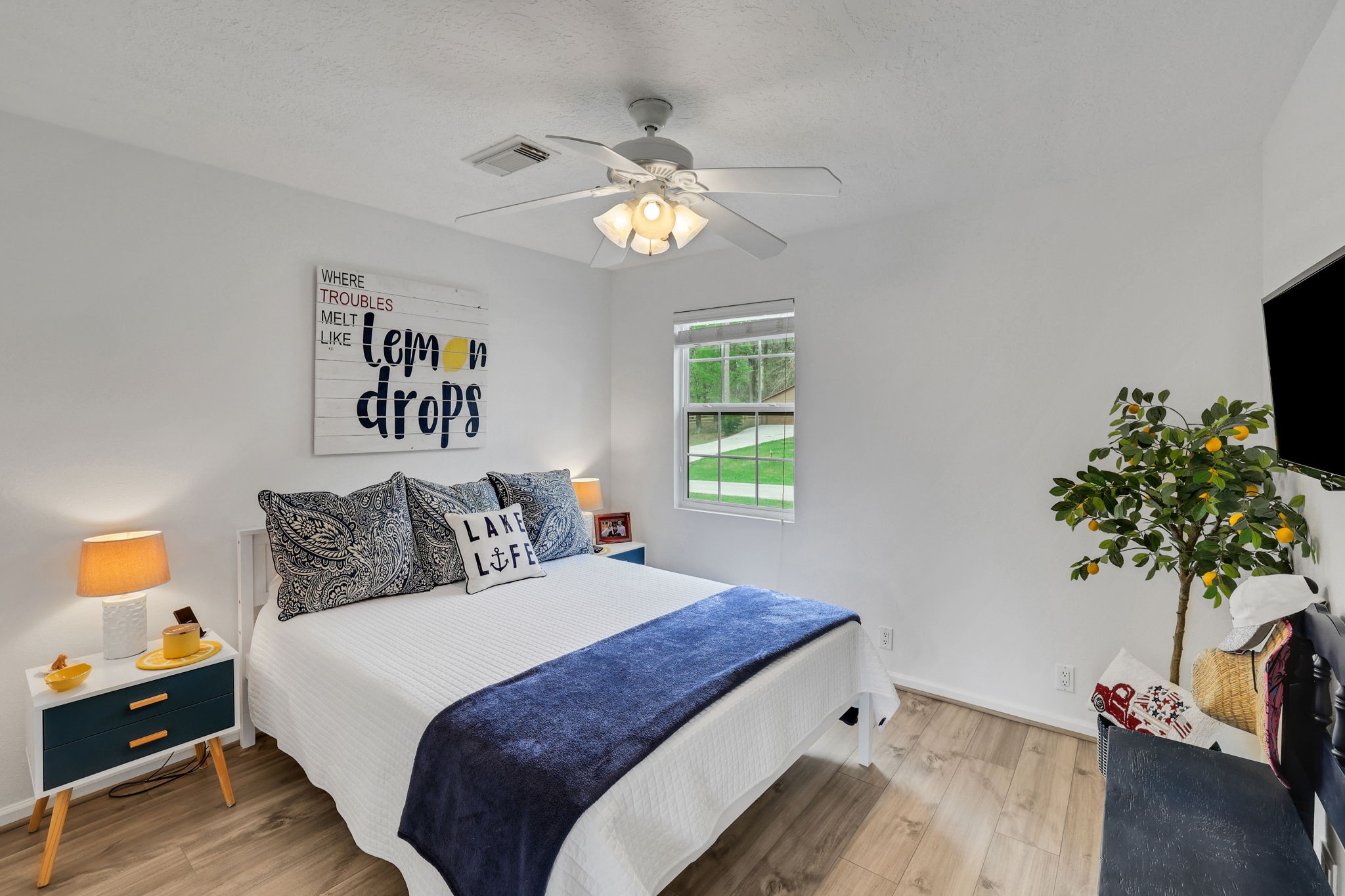 331 Holiday Lane Coldspring, TX 77331 - Photo 36 of 36 This cozy secondary bedroom features a bright, welcoming atmosphere with natural light streaming through the window. It includes a ceiling fan and engineered wood flooring.