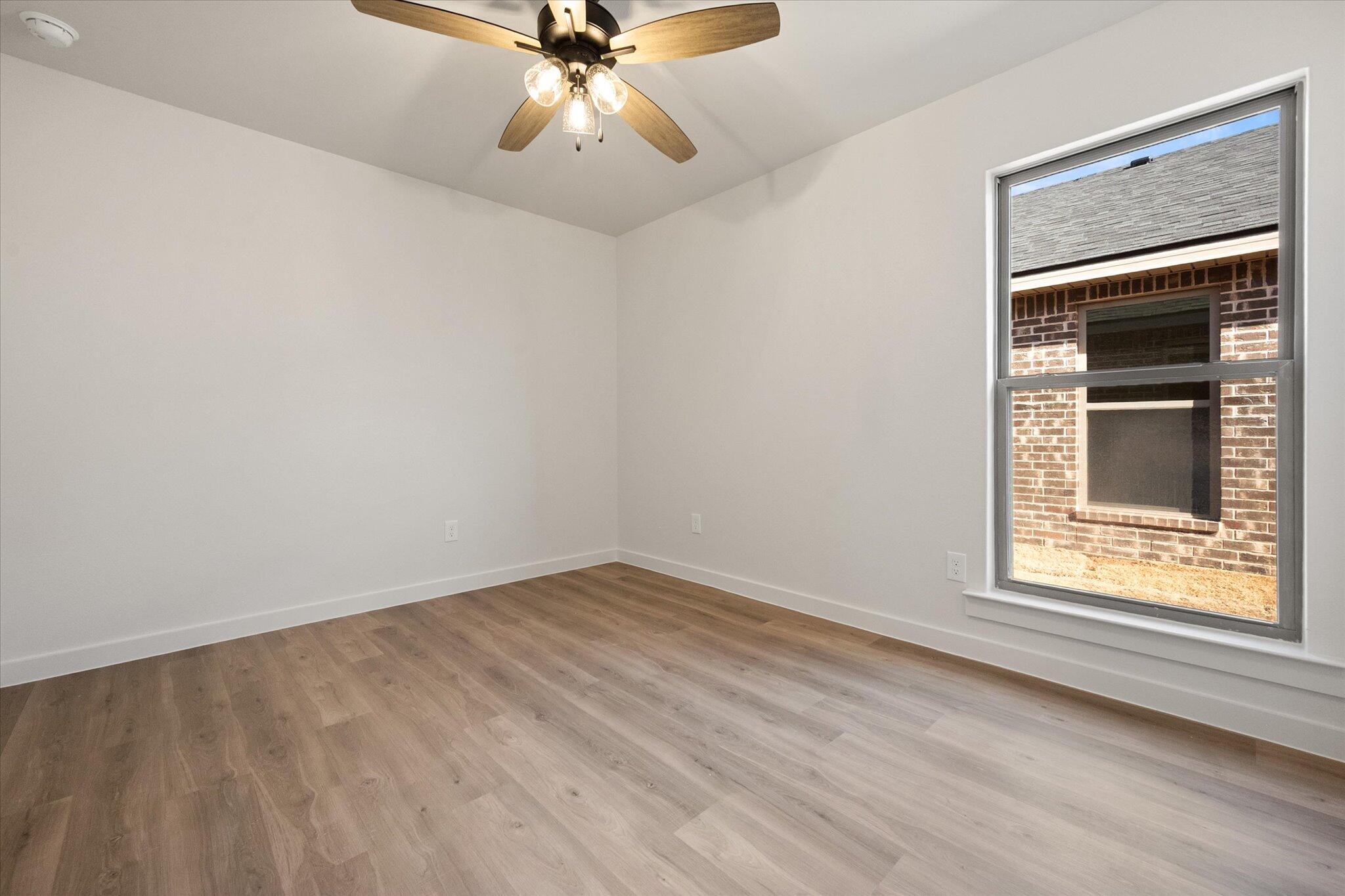 7203 7th Street Lubbock, TX 79416 - Photo 15 of 20 wooden floor in an empty room with a window